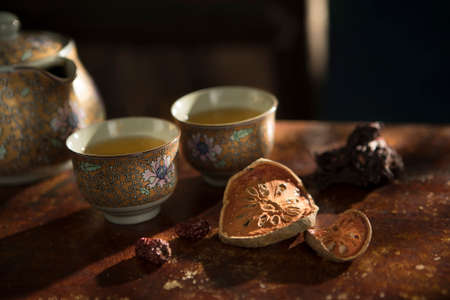 Close up view of nice china teapot and glasses on color backの写真素材