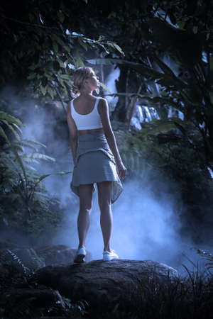 portrait of nice young woman is walking  in the jungle at midnightの写真素材