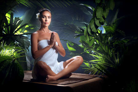 Portrait of young woman practicing yoga in tropic environmentの写真素材