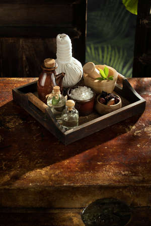 close up view of mortar, salt, oil and Herbal Compress on color back.の写真素材