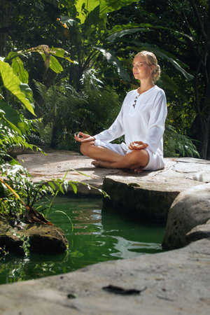 Portrait of young woman practicing yoga in tropic environmentの写真素材
