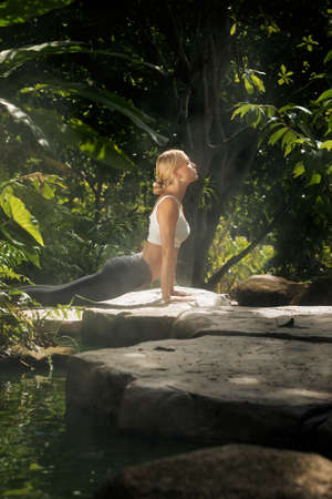 Portrait of young woman practicing yoga in tropic environmentの写真素材