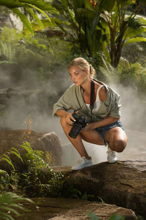 portrait of nice young woman is taking picture in the jungleの写真素材