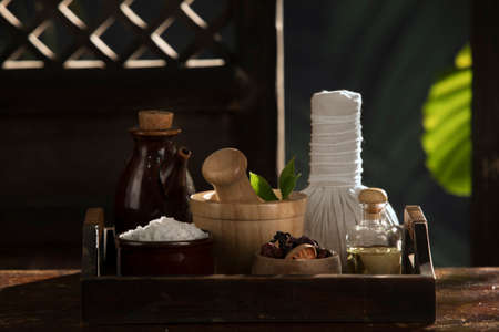 close up view of mortar, salt, oil and Herbal Compress on color back.の写真素材