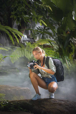 portrait of nice young woman is taking picture in the jungleの写真素材