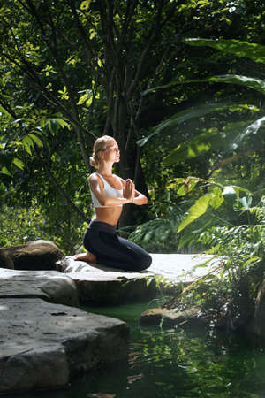 Portrait of young woman practicing yoga in tropic environmentの写真素材