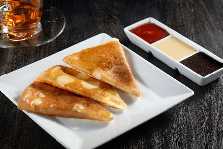 close up view of nice yummy crepes with jam on grey tableの写真素材