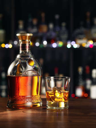 close up view of bottle of whiskey and glass aside on color back.の写真素材