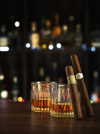 Closed up view of glass of whiskey with cigars on color backの写真素材