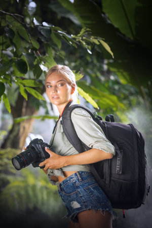 portrait of nice young woman is taking picture in the jungleの写真素材