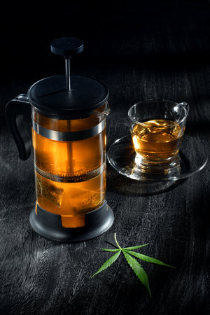 Close up view of tea pot and cup with hemp tea on grey backの写真素材