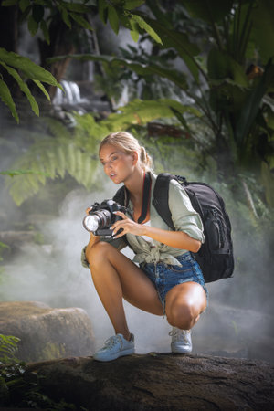 portrait of nice young woman is taking picture in the jungleの写真素材