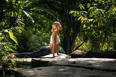 Portrait of young woman practicing yoga in tropic environmentの写真素材