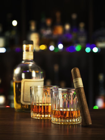 close up view of cigar, bottle of whiskey and glass on color back.の写真素材