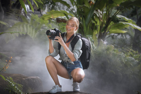 portrait of nice young woman is taking picture in the jungleの写真素材