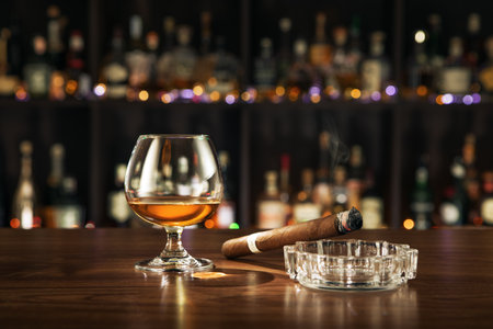 close up view of cigar and glass aside on color back.の写真素材