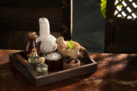 close up view of herb, salt, oil and Herbal Compress on color back.の写真素材