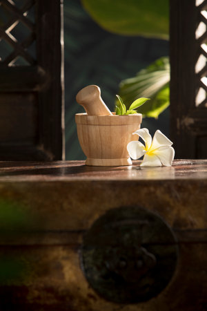 view of wooden mortar on color tropic authentic backの写真素材