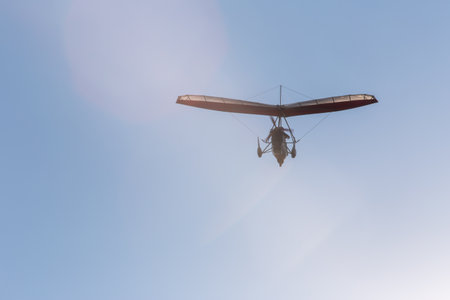 Motorized hang glider soaring in the blue sky