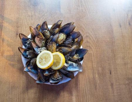Seafood Dish open and ready mussels with lemon on the table