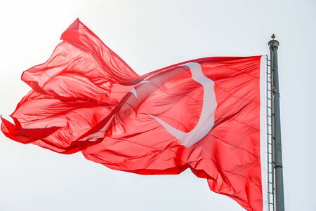 Turkish flag waving under the blue clear sky.