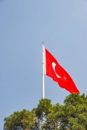 Turkish flag is waving in blue open sky.の写真素材