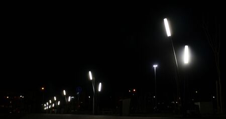 Public lights in the dark night street and cars passing trough on the background. izmir city,...