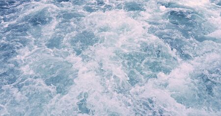 Close up powerful waves pulled out from fasting boat. Water foam trace behind the ship.