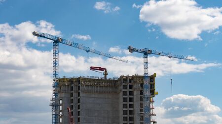 Timelapse view of skyscraper building construction with cranes on the roof. 4K.