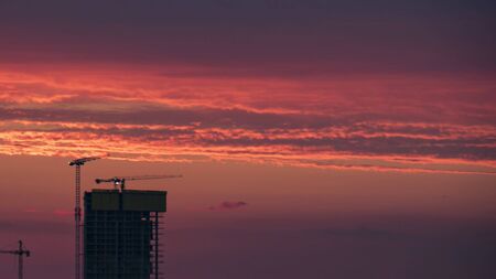 Construction site and crane silhouette with red color sunset. izmir Turkey.