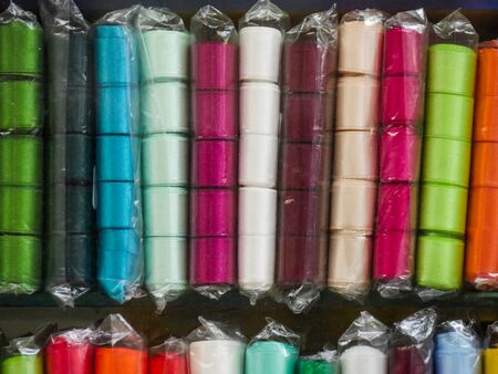 Multi-colored ribbon on the shelf. Textile shop. Sewing goods store. Bright handmade concept....
