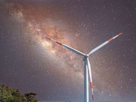 Wind turbine front of milky way at night. Renewable alternative energy.の写真素材