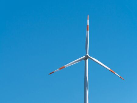 Wind turbine with clear blue sky background. Renewable alternative energy.
