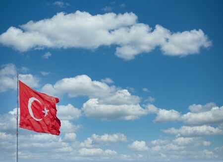 Turkish flag waving front of clouds. Background.