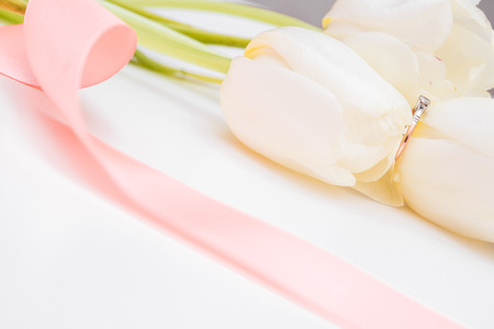 tulip and gold engagement ring on a white backgroundの写真素材