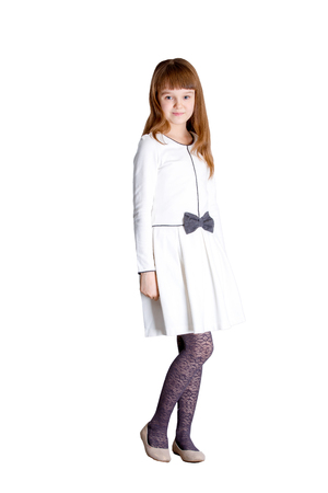 Pretty little girl wearing white dress standing on white backgroundの写真素材