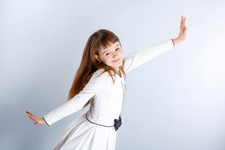 Smiling little girl in the white dressの写真素材