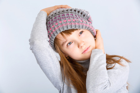 adorable smiling child girl wearing grey knitted hatの写真素材