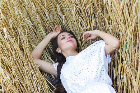 Young  woman in white dress in wheat field. girl in wheat fieldの写真素材