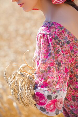 Happy girl in hat on wheat field. Big hat and blowing long hairの写真素材