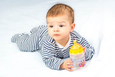 the baby drinking milk from the bottleの写真素材