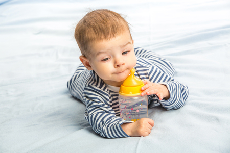 the baby drinking milk from the bottleの写真素材