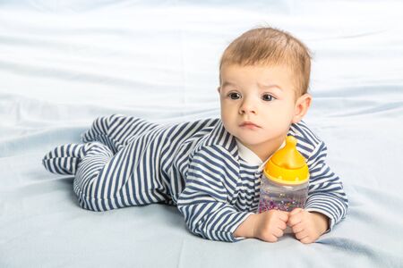 the baby drinking milk from the bottleの写真素材