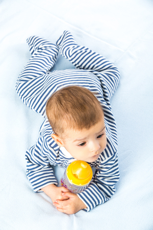 the baby drinking milk from the bottleの写真素材