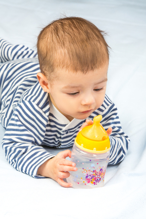 the baby drinking milk from the bottleの写真素材