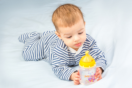 the baby drinking milk from the bottleの写真素材