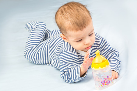 the baby drinking milk from the bottleの写真素材