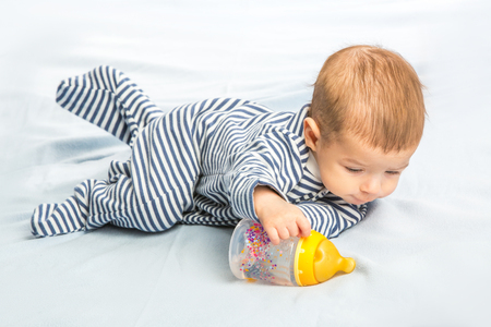 the baby drinking milk from the bottleの写真素材