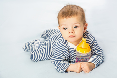 the baby drinking milk from the bottleの写真素材