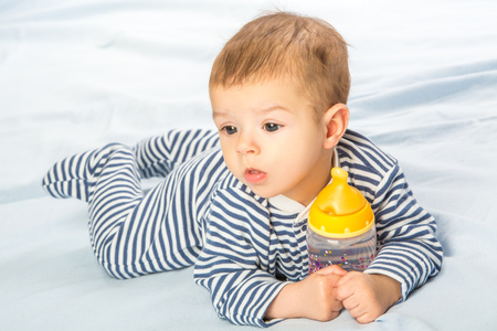 the baby drinking milk from the bottleの写真素材